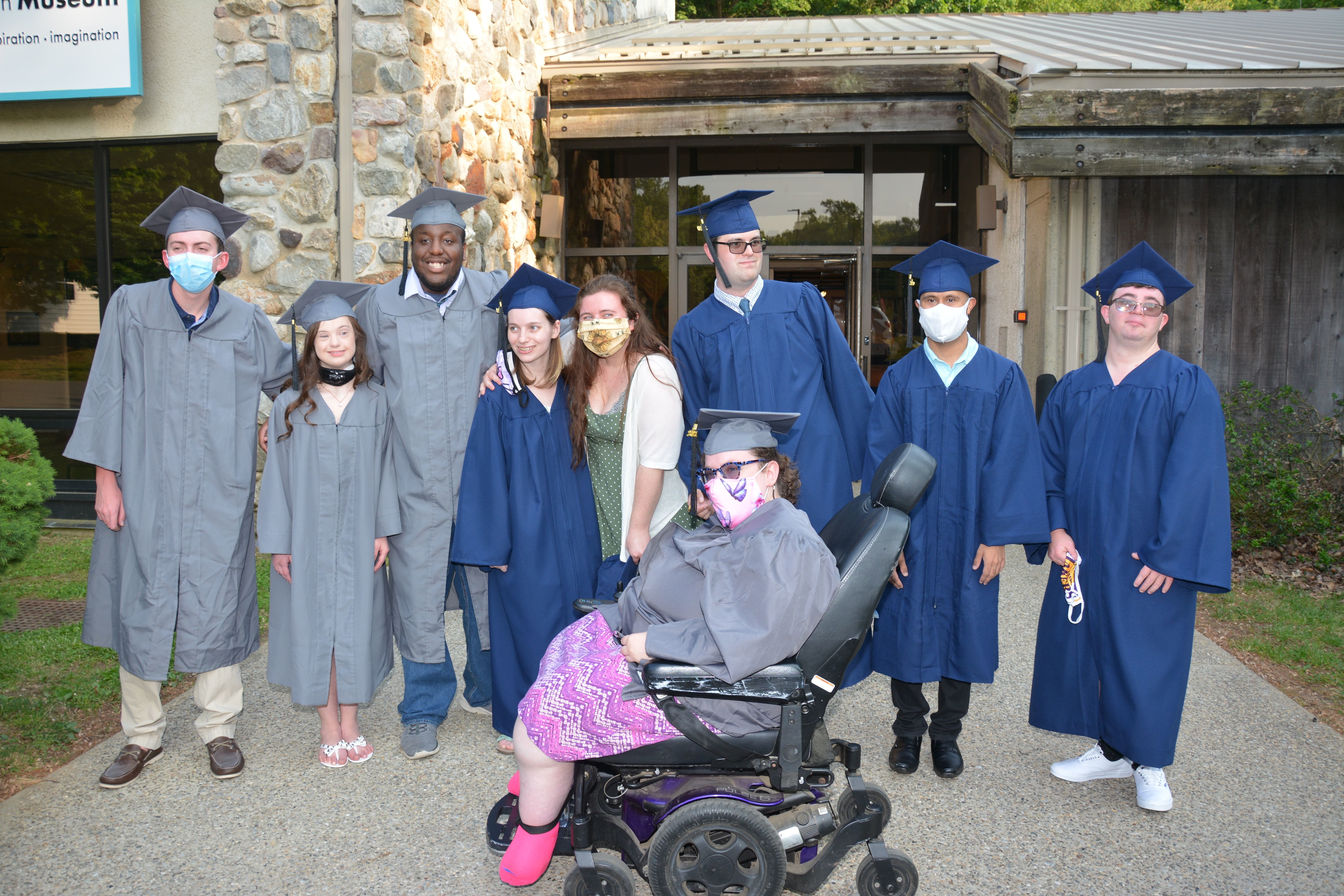 2020-2021 Kach Graduates stand in cap and gown on graduation day.