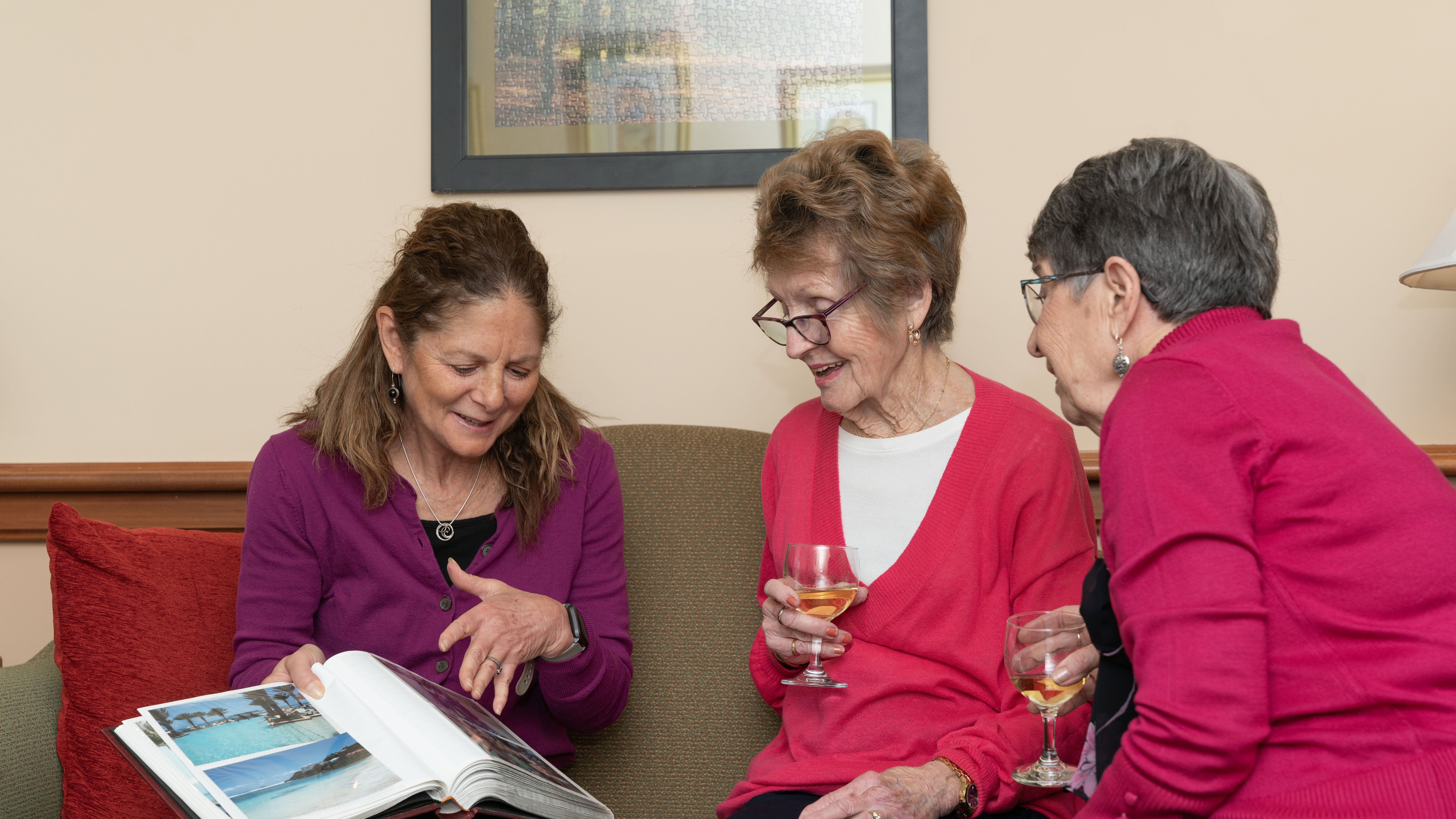 Women laughing looking at a photo book