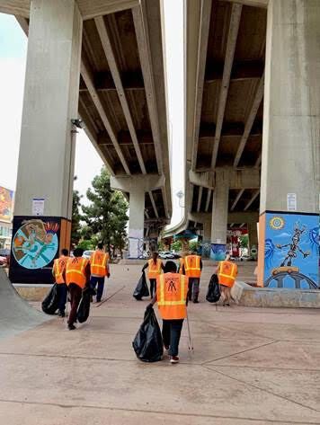 Several Wheels of Change volunteers cleaning up trash.