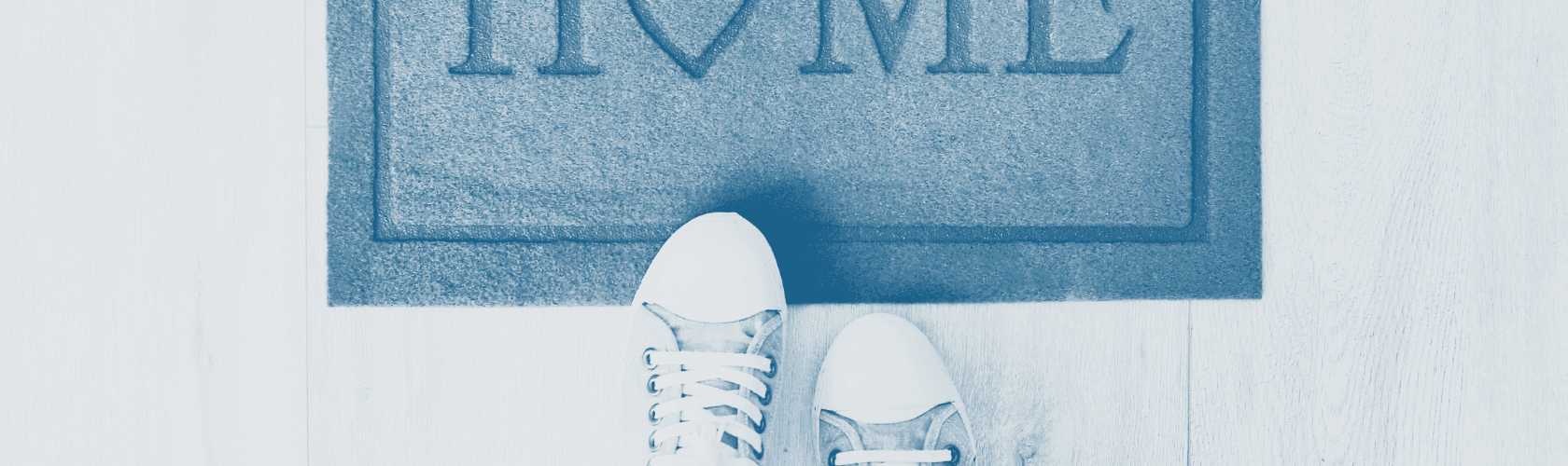 Image shows a pair of feet in sneakers stepping onto a mat that reads "home"