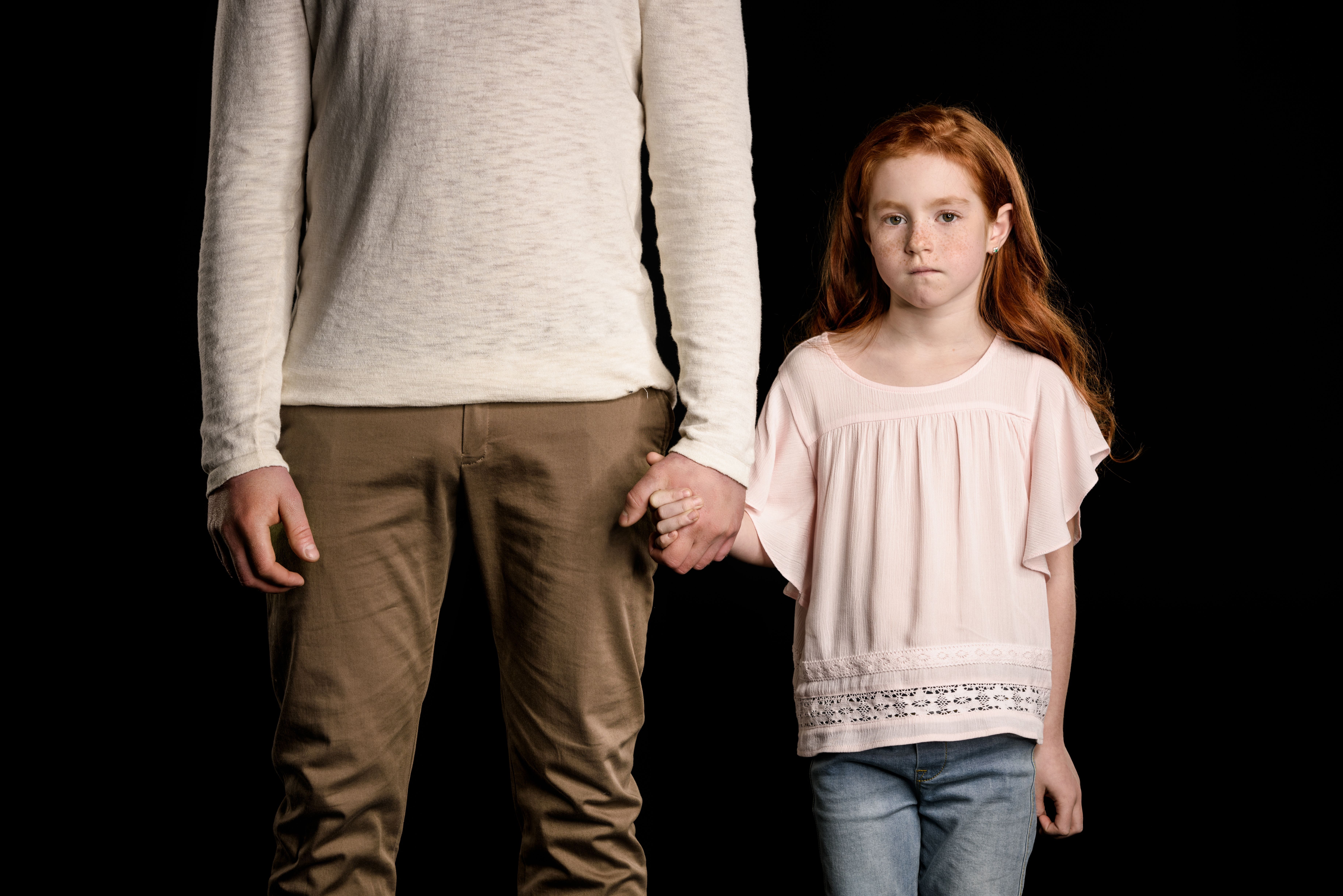 father and red headed daughter holding hands