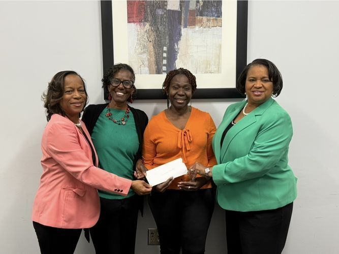 four women holding grant check