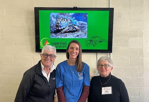 Volunteers posing before a box turtle display