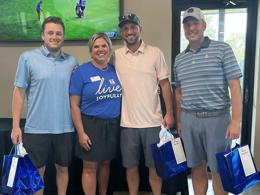 Christie Hinrichs poses with Westgate Bank's Sertoma Golf Event golf scramble champs.