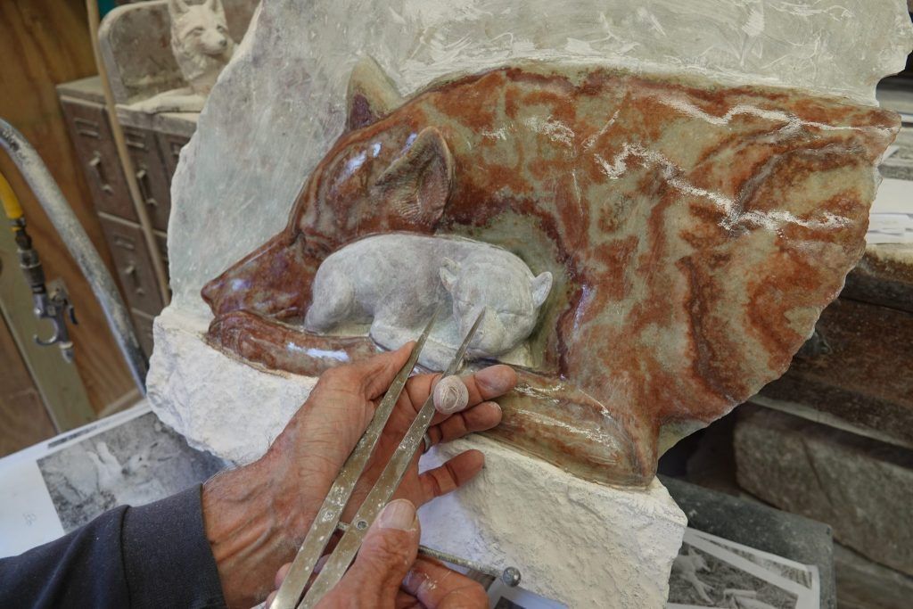 Dale using tools to measure the pup he is carving