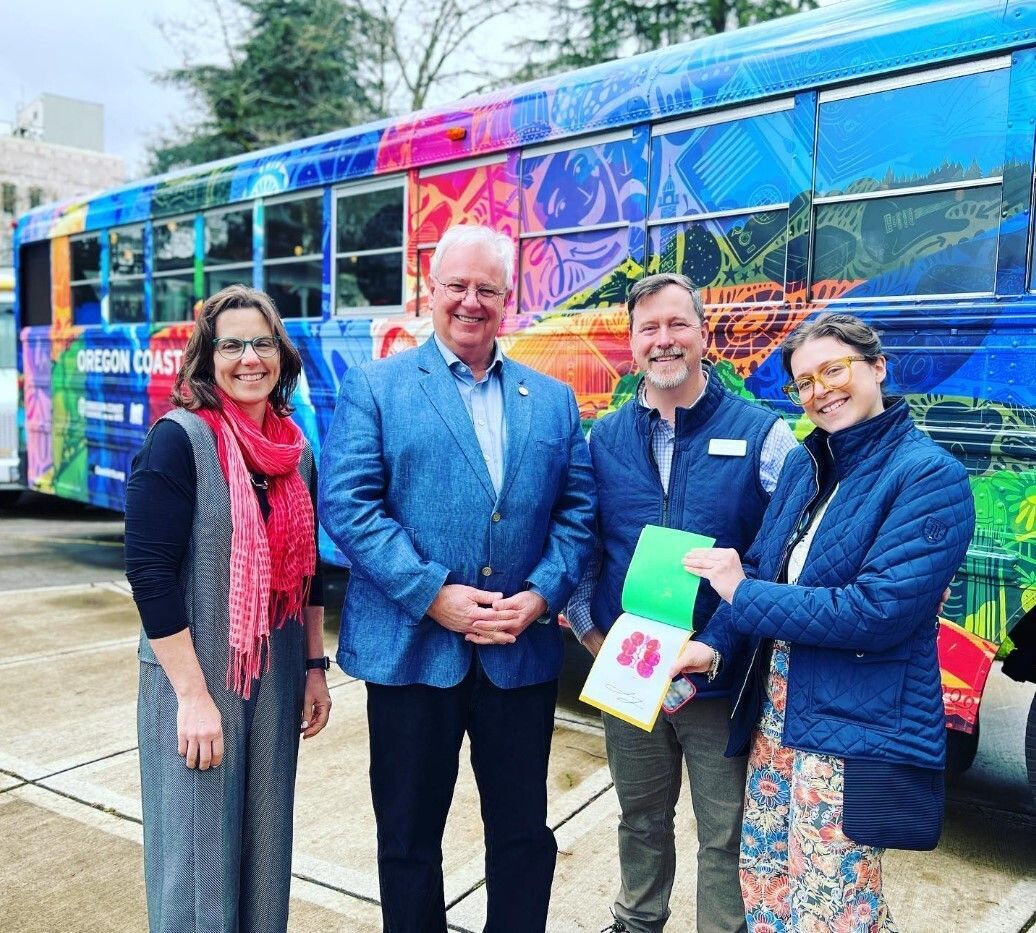 Niki Price of the Lincoln City Cultural Center, Rep. David Gomberg, Jason Holland of the Oregon Coast Council for the Arts, and Lisa Lipton of Newport Symphony Orchestra in front of the Oregon Coast Art bus in Salem, Oregon