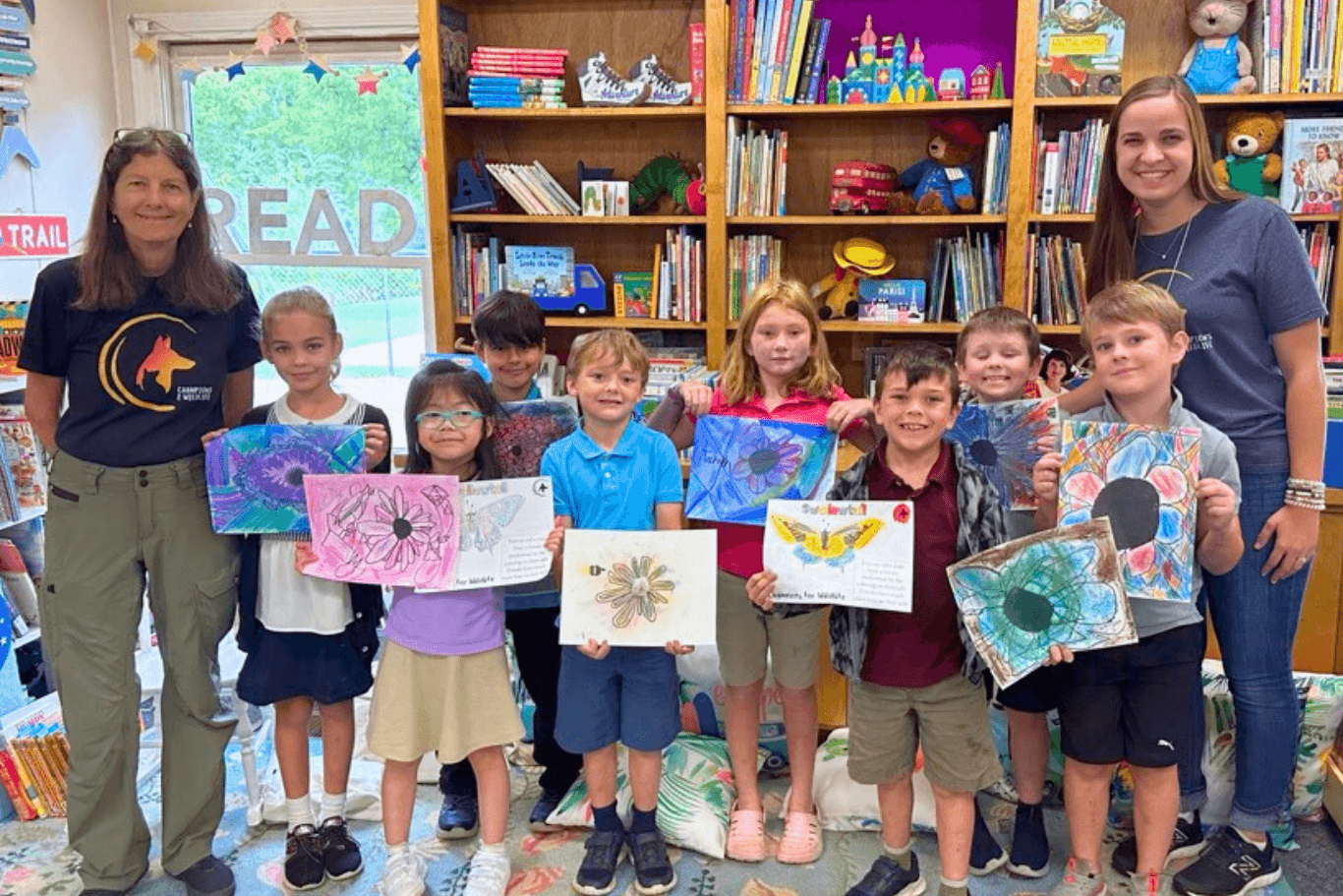 Students display their colorful drawings of pollinators