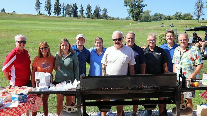 A group of adults face the camera on a golf course