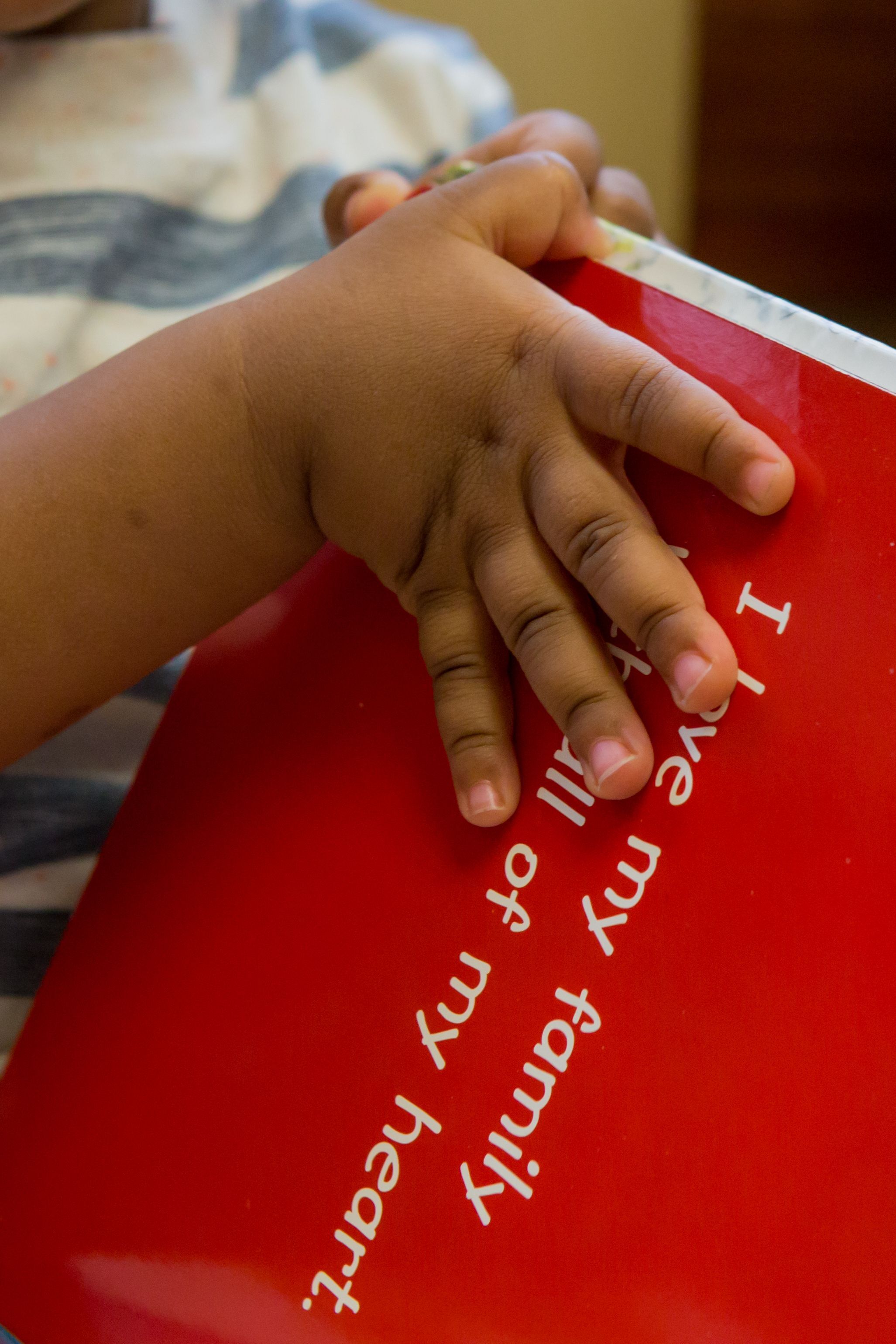 Small child's hands hold board book