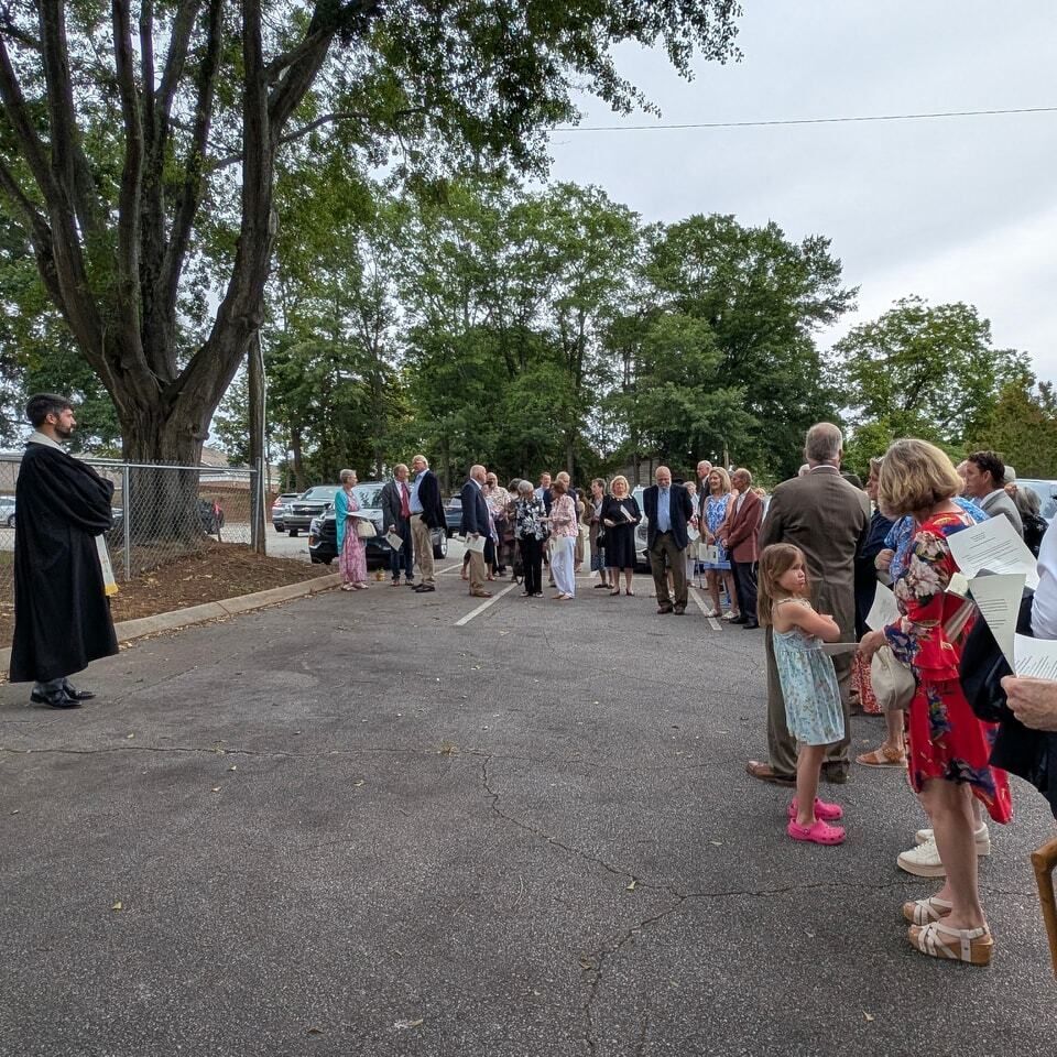 Group of church members gathered in a crowd, as pastor stands in front for the groundbreaking ceremony