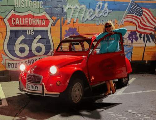 Picture of woman standing next to a car at Mel's diner in California