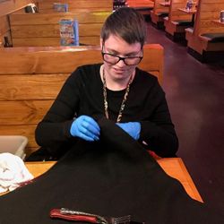 Young woman putting together fabric items