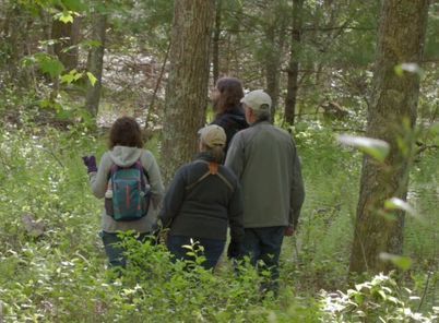 Charles Clarkson in the forest with volunteers