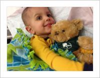 Little boy hugging Webster the teddy bear