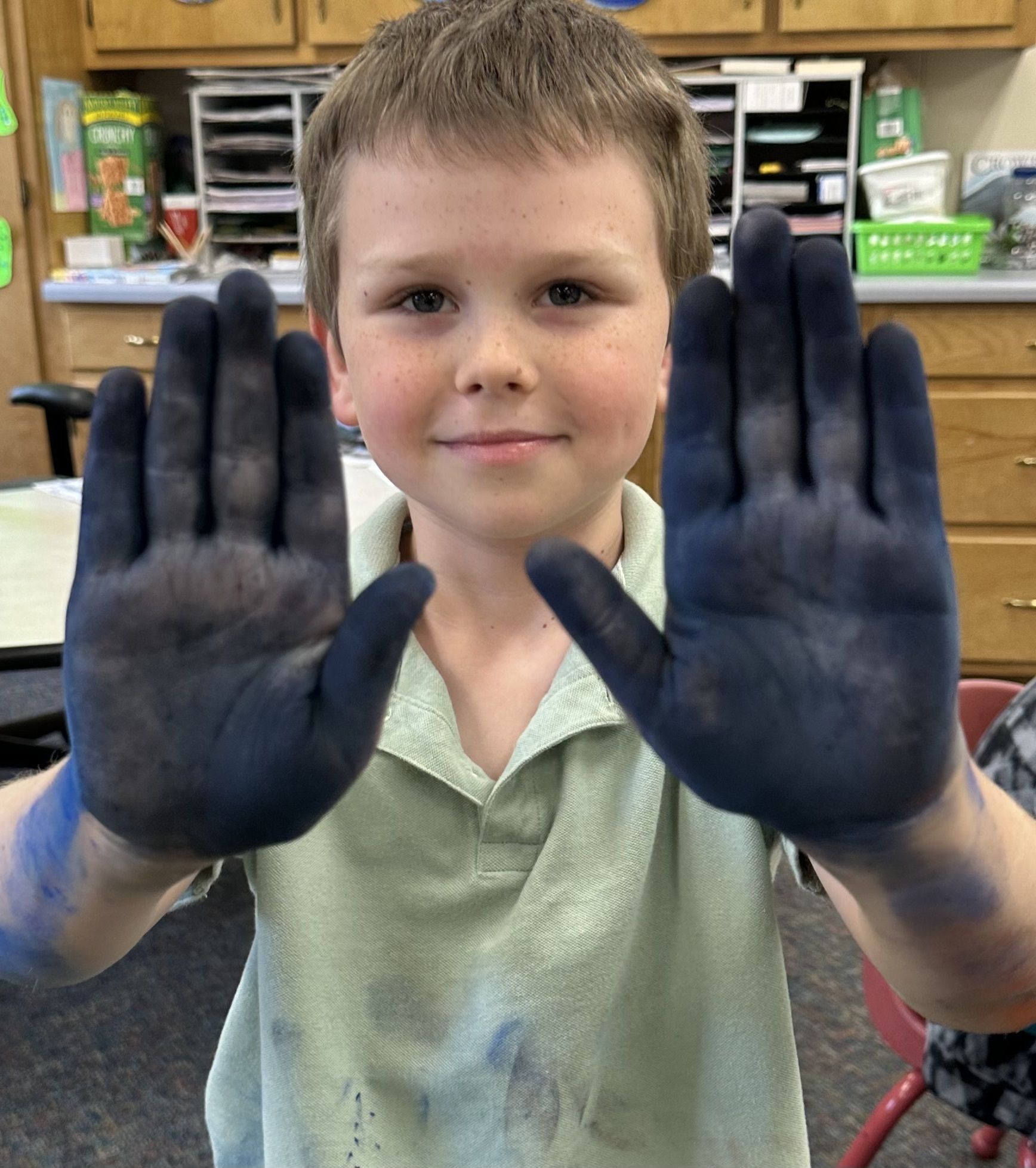 Student with messy hands after doing an art project