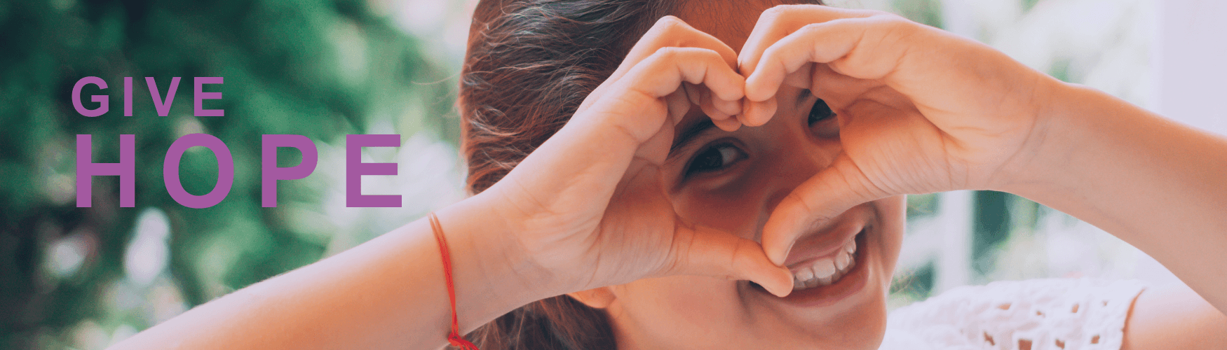 young girl making a heart shape with her hands