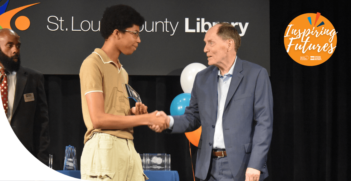 boy shaking hand with a man on a stage