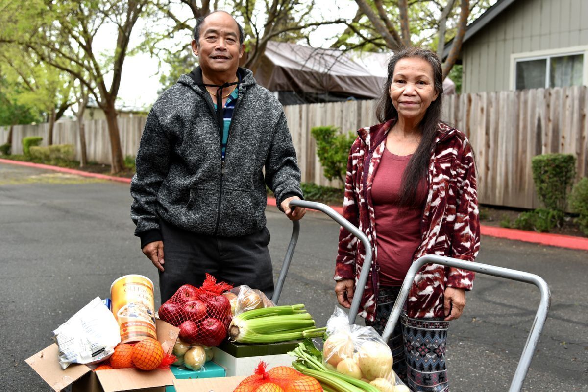 Senior couple each with a trolly holding boxes full of fresh food