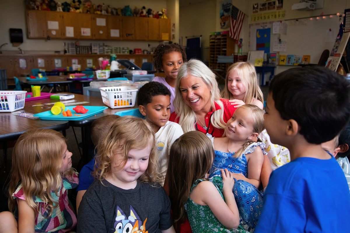 a class posing for a picture with their smiling teacher 