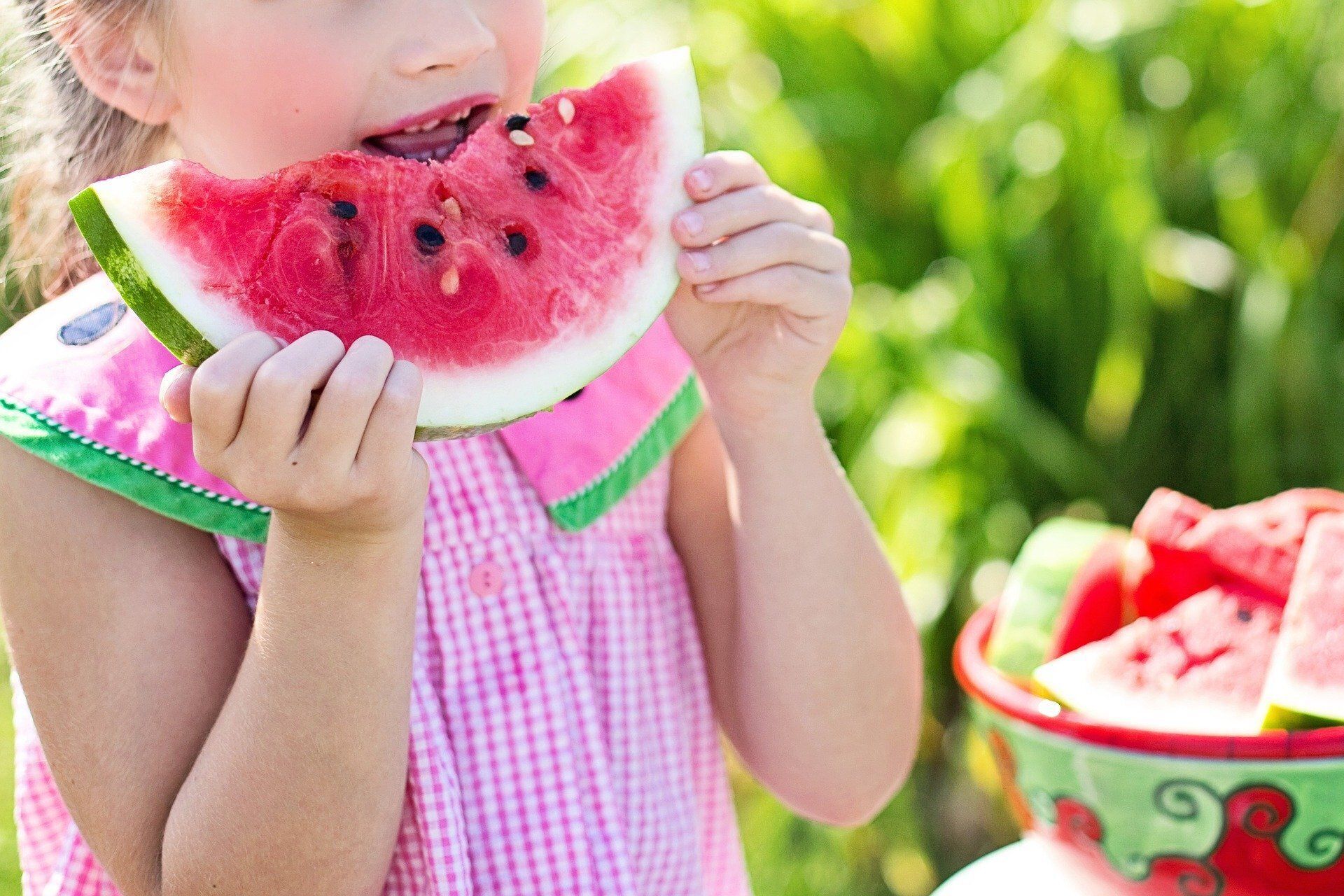 Young girls eating a watermelon on a sunny day