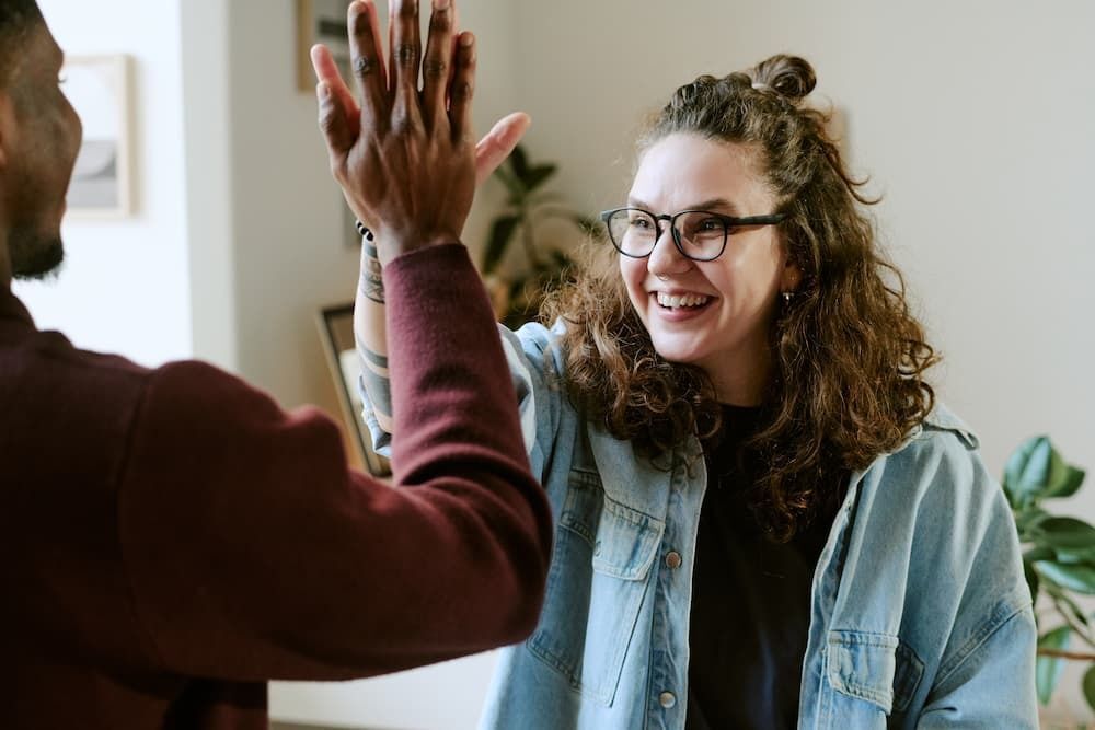 Woman high fiving a partner as they navigate the mental health field for their clients