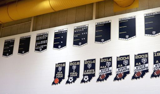 Gym wall with team championship boards and state champ signs, custom signs