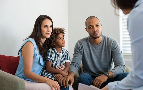 parents and child on a couch in a session with a worker