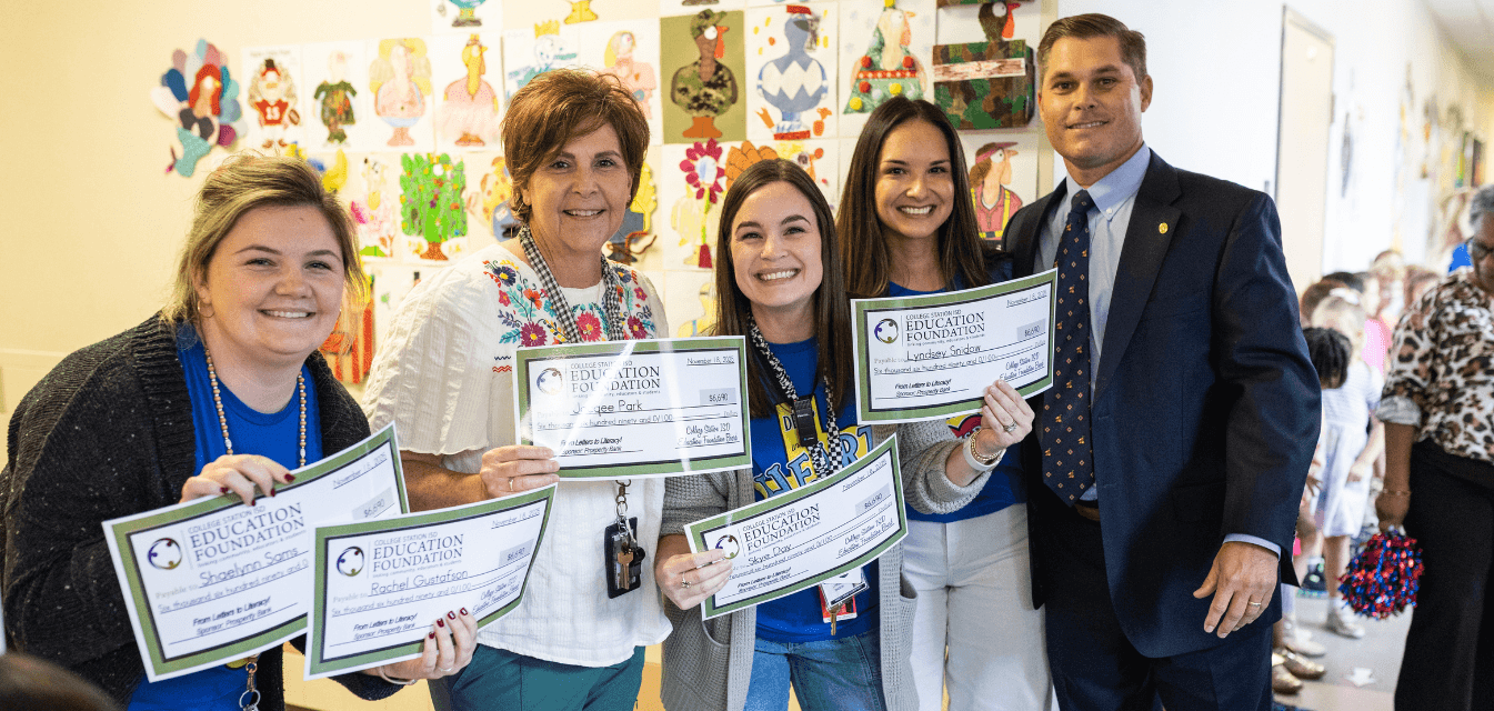 Teacher with checks from the Education Foundation
