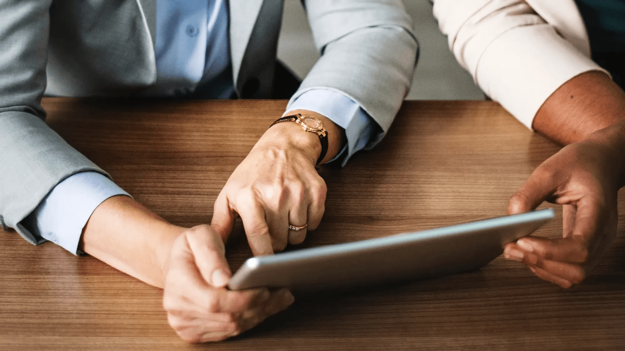 Two people work on a tablet