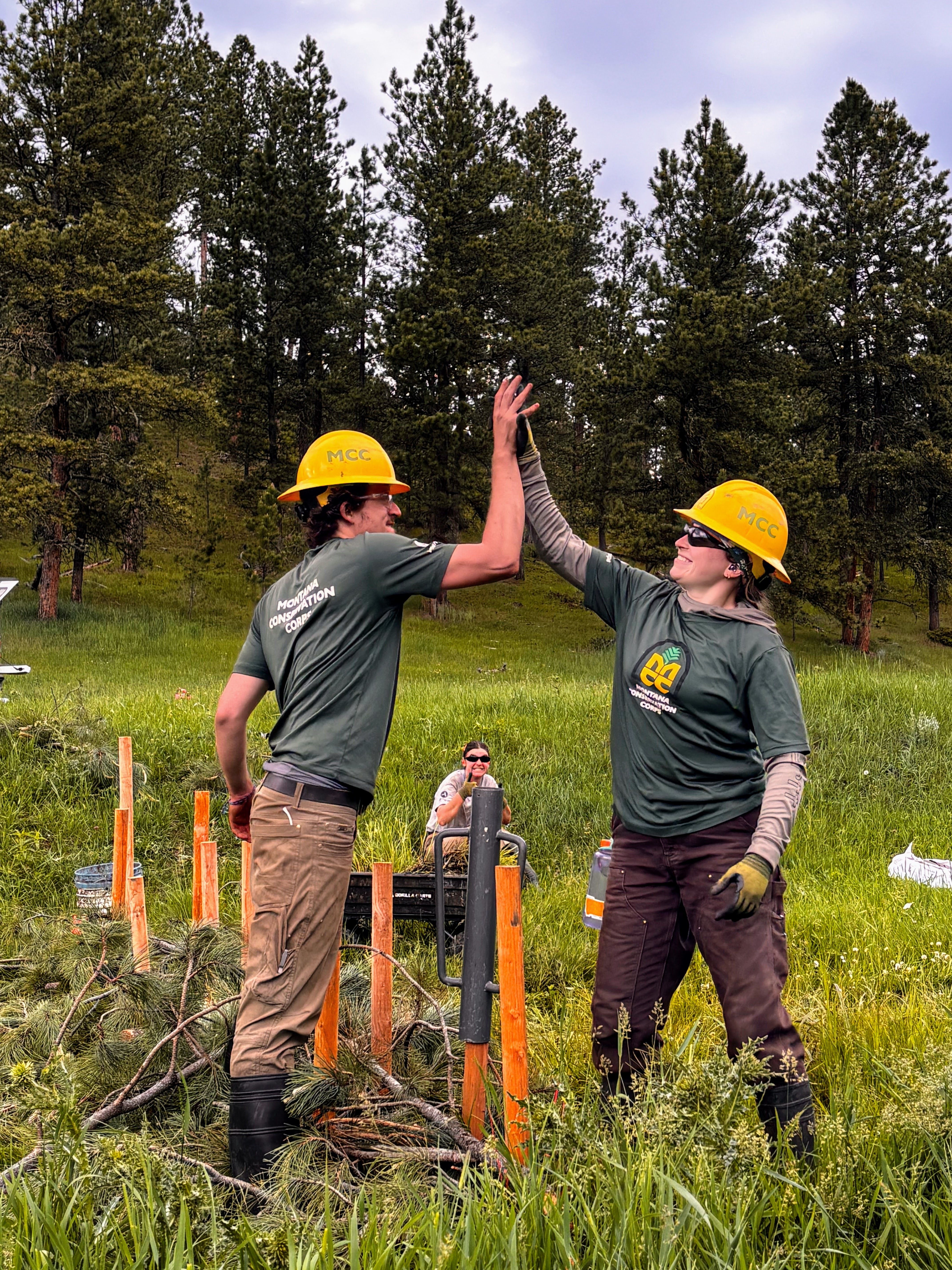 Two crew members high five with success!