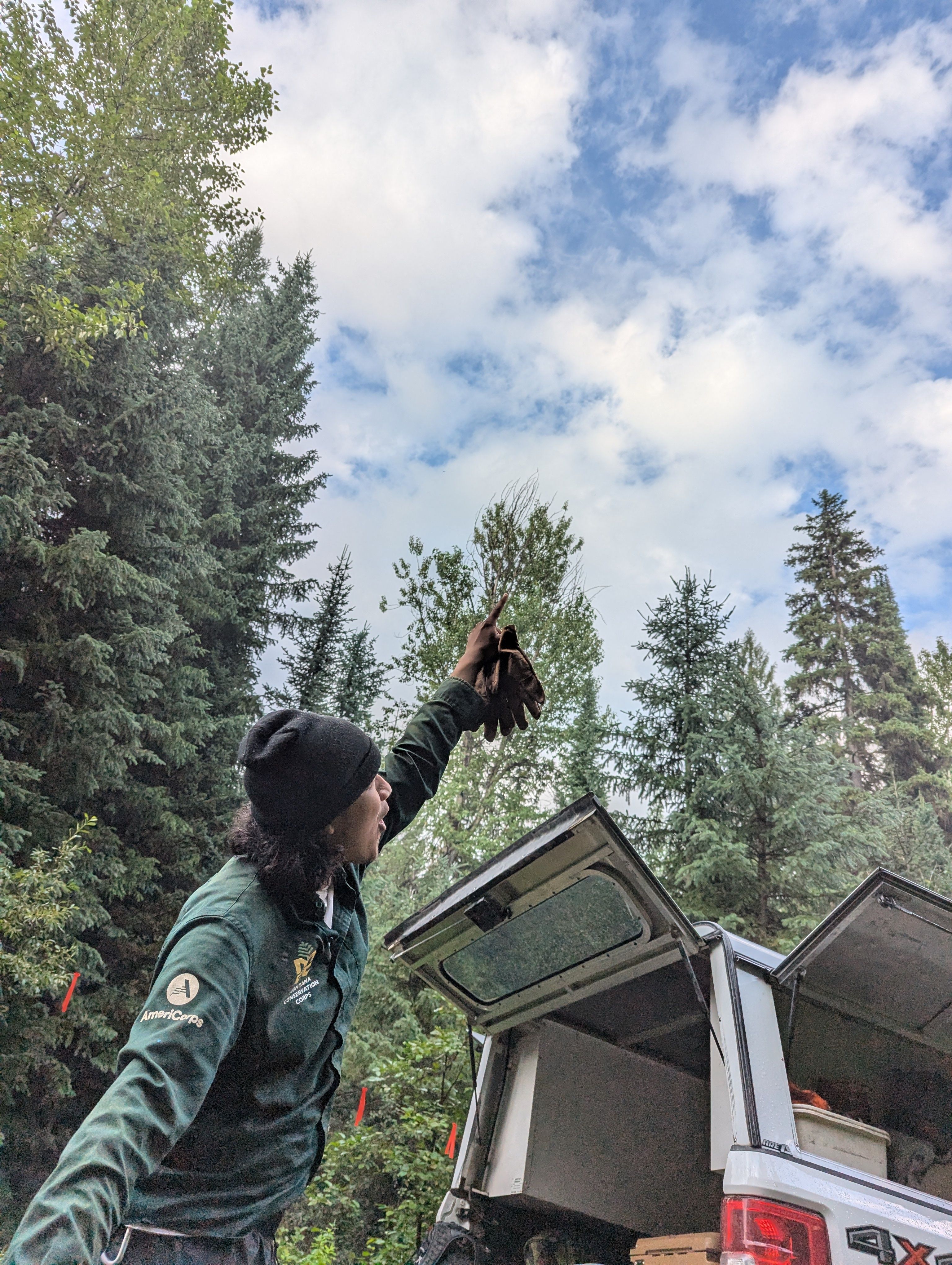 A crew member points at the sky with a surprised and happy look on their face.