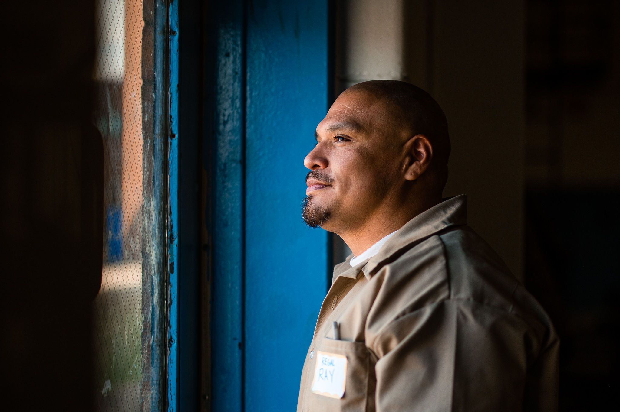 Man looks outside prison gymnasium doors.