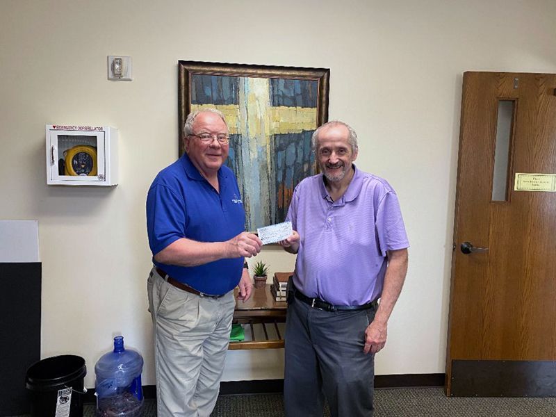 Grace Senior Pastor Tom Brodbeck presents check to Habitat Faith Relations Associate Kermit Rowe.