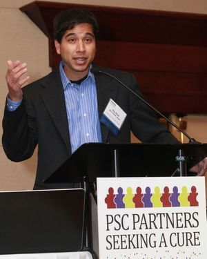 A PSC researcher speaking at a podium. The PSC Partners logo is on the front of the podium.
