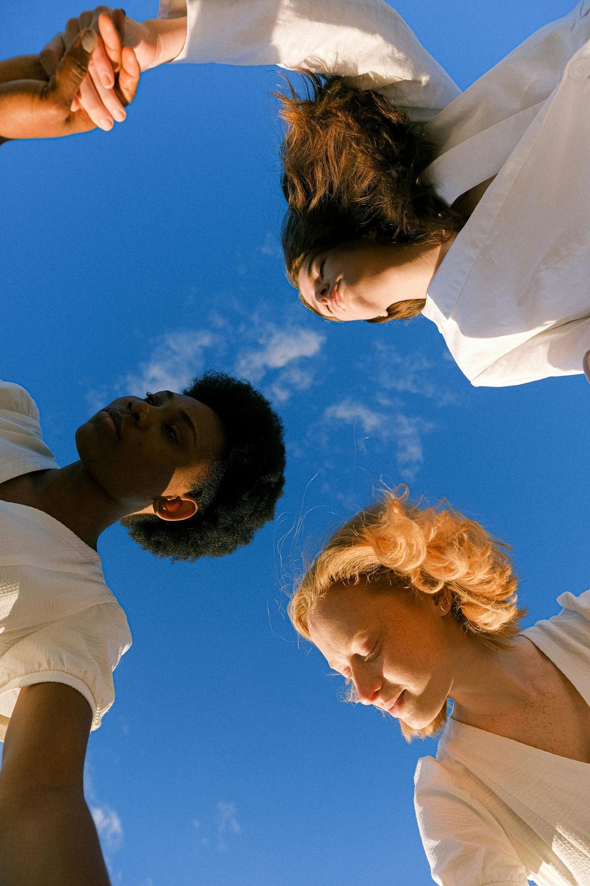 group of teens in white tshirts under a clear blue sky