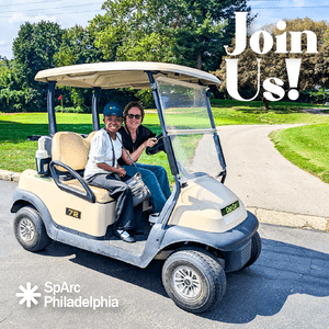 Two woman in golf cart smiling on a sunny day