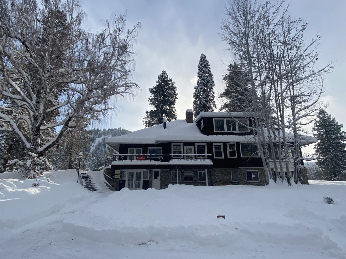 A brown building called the River Haus in the winter time covered in snow.