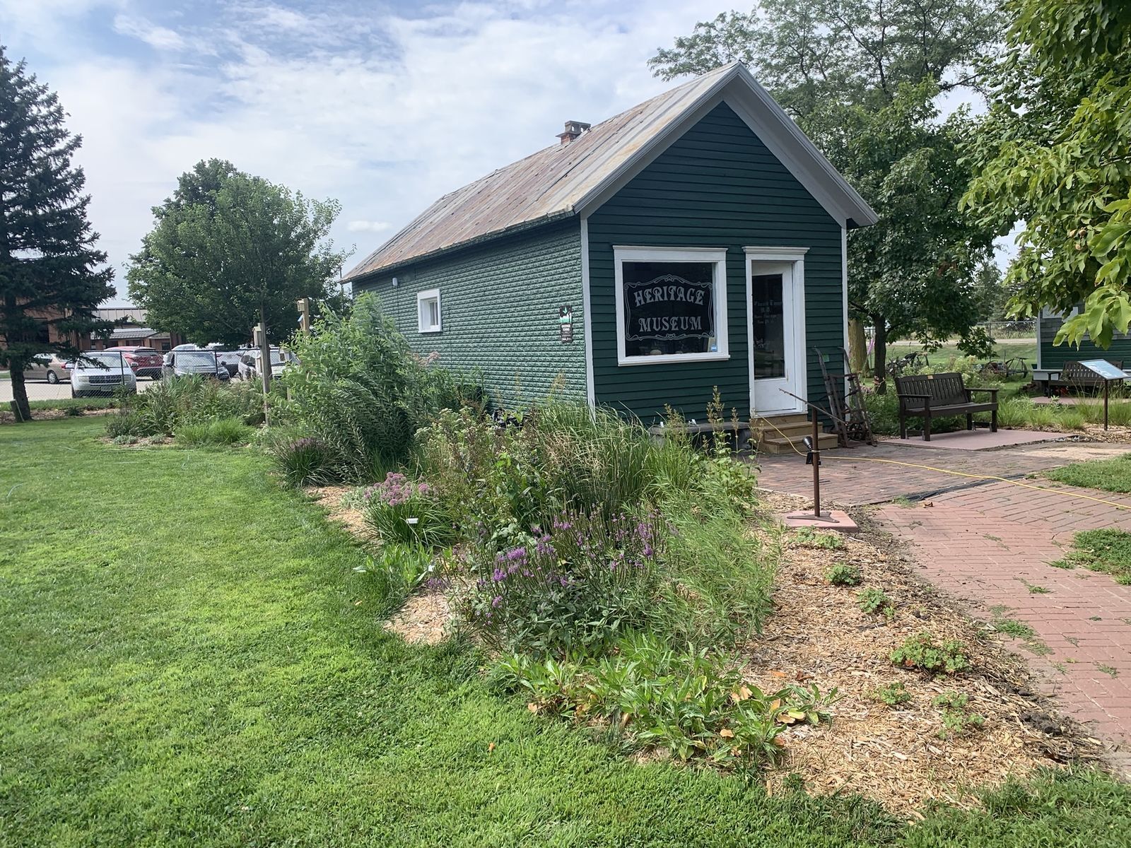 A native garden outside a small green shed in a neighborhood park