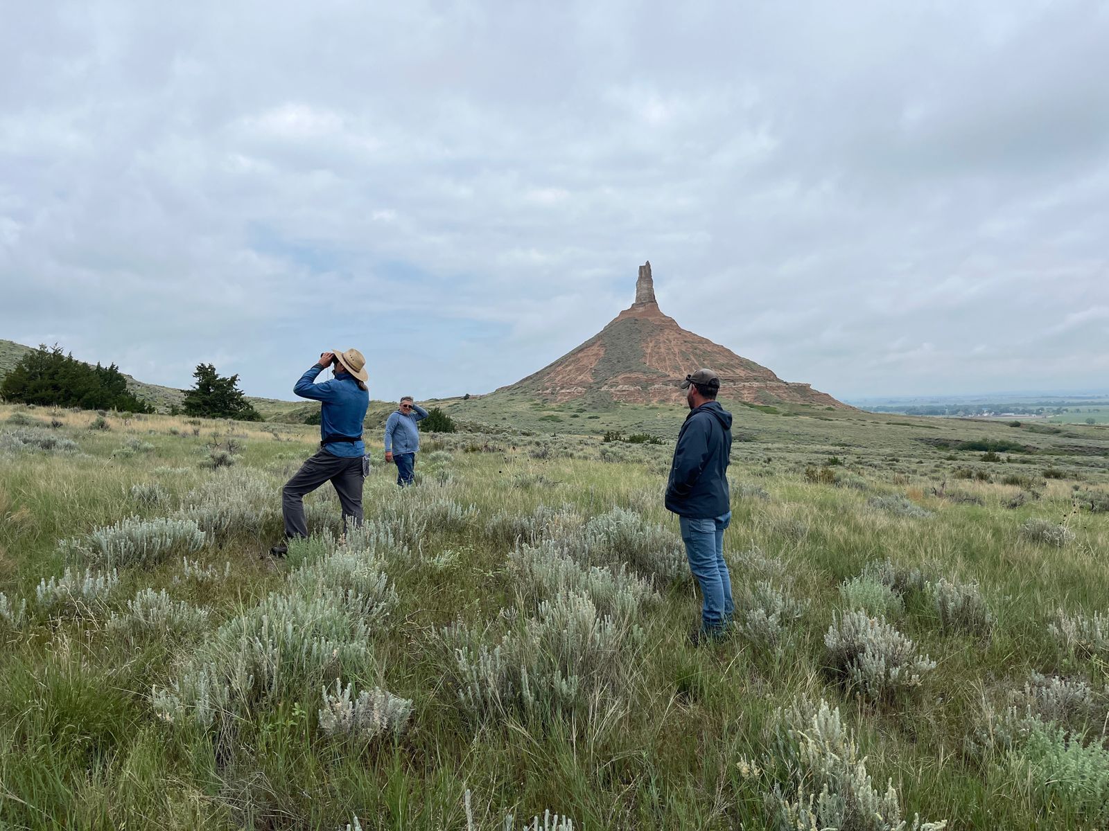 Hikers exploring wildflowers with Chimney Rock in the background