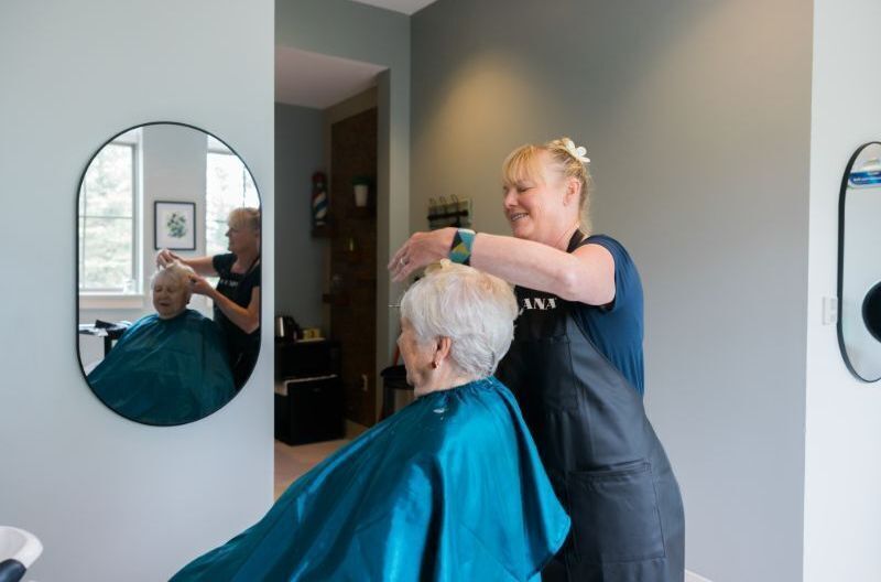 Woman receiving a haircut in the salon at Casey's Pond Senior Living Community in Steamboat Springs