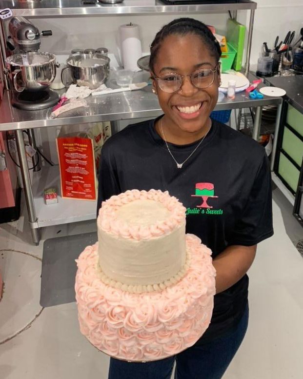 Anastasia Tucker Posing with A Cake She Decorated For Julie's Sweets Bakery.