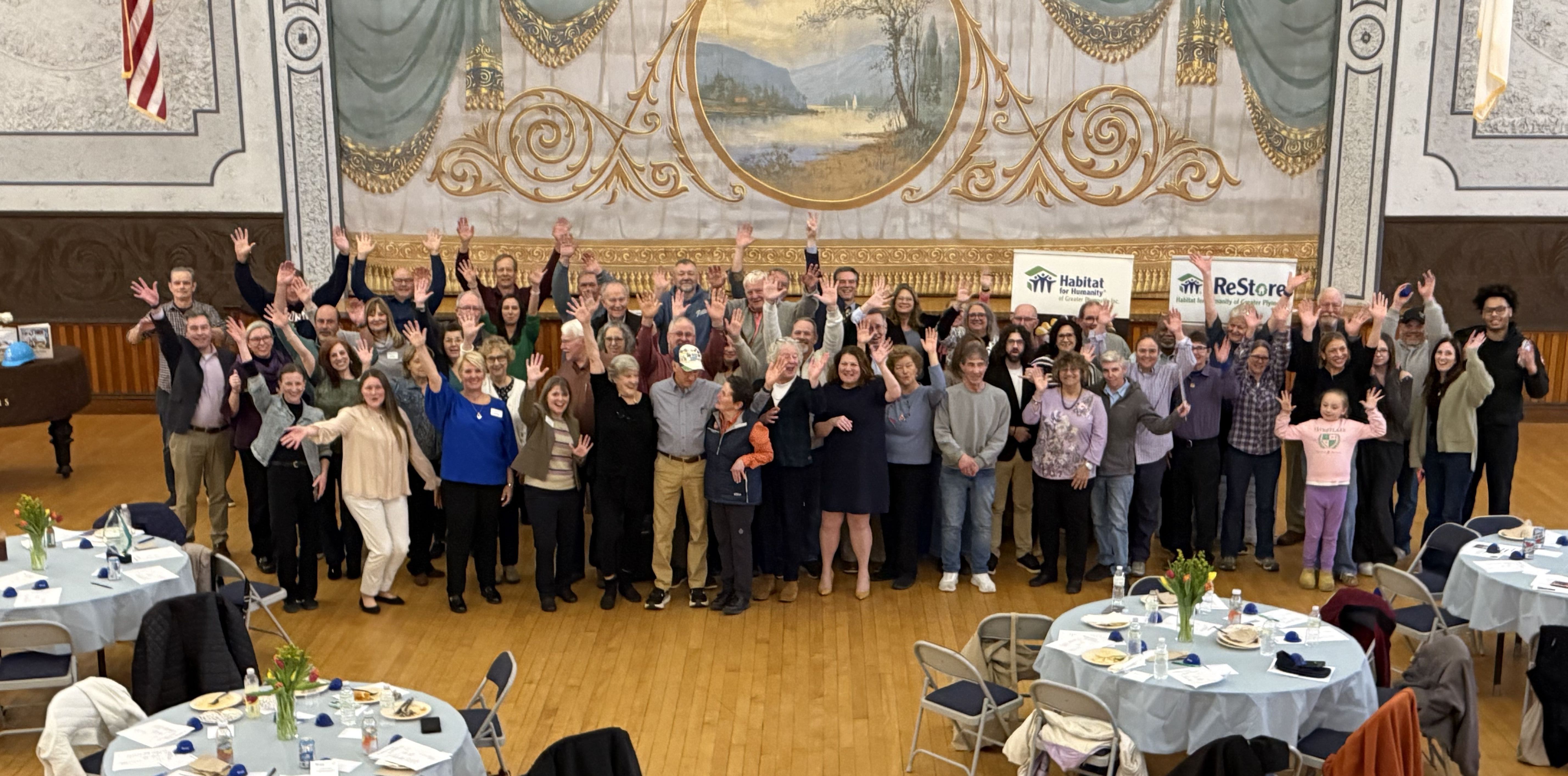 A group of Habitat volunteers sit in a window space on a new construction home site