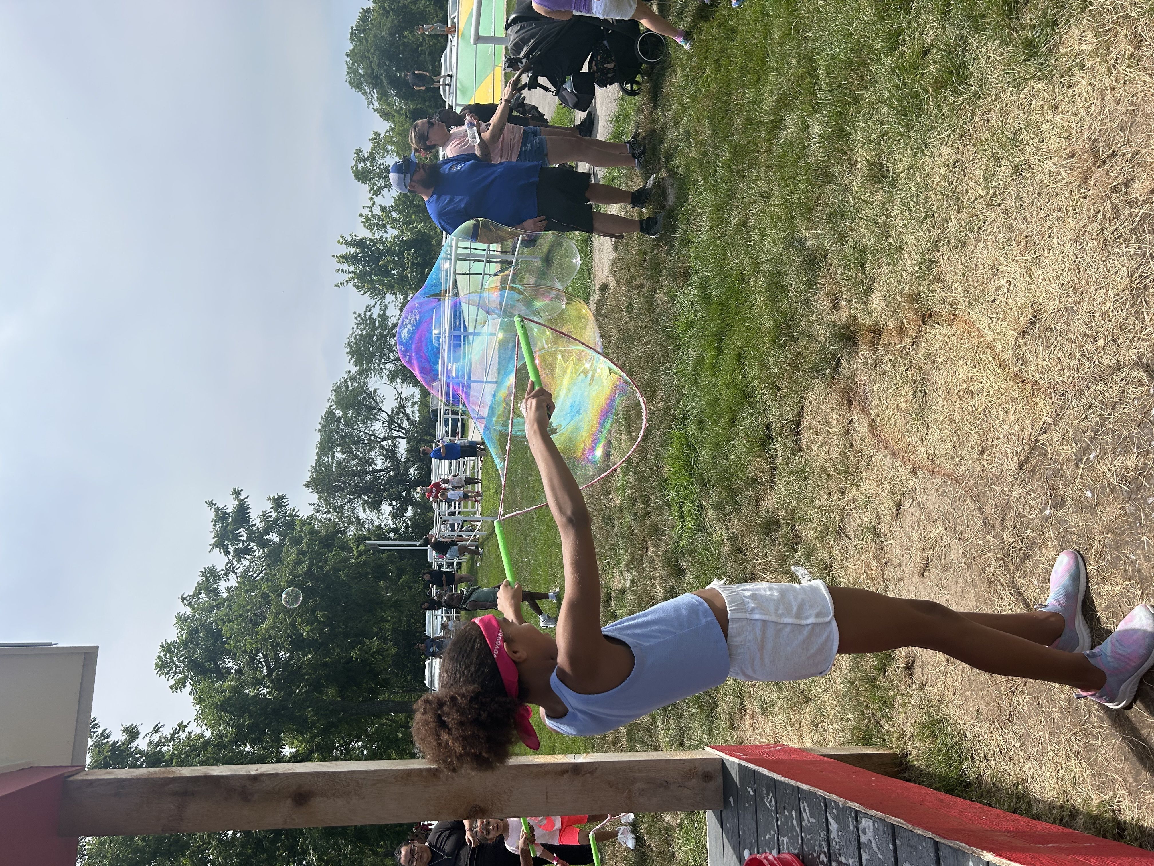 Child waving a huge bubble