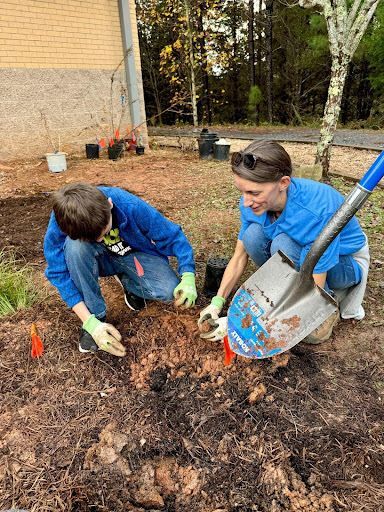 Volunteer helping to plant in a pollinator garden