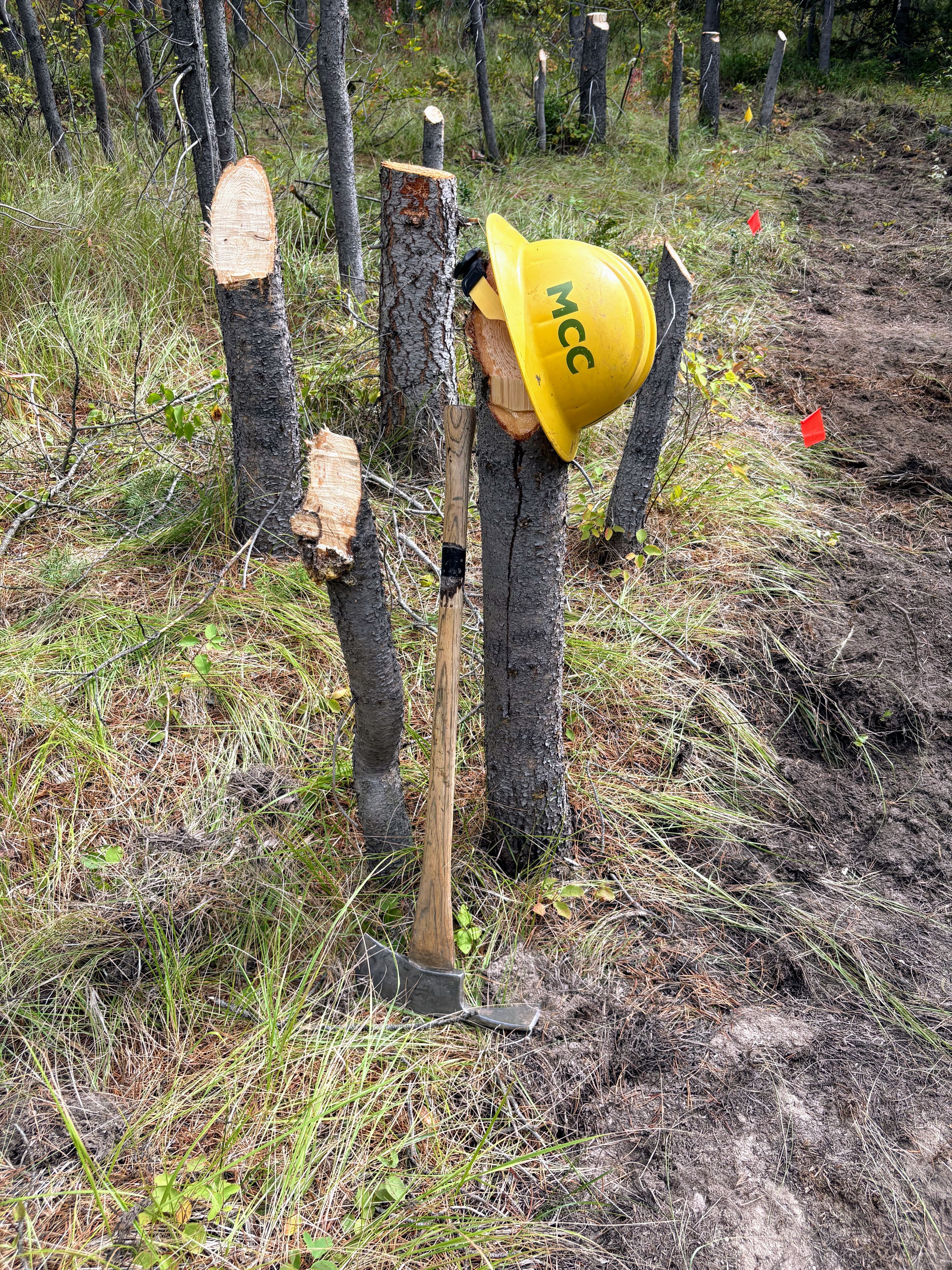 An MCC helmet hangs on a post in the ground