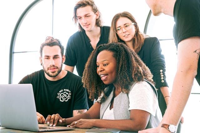 Corporate setting, people around a desk computer