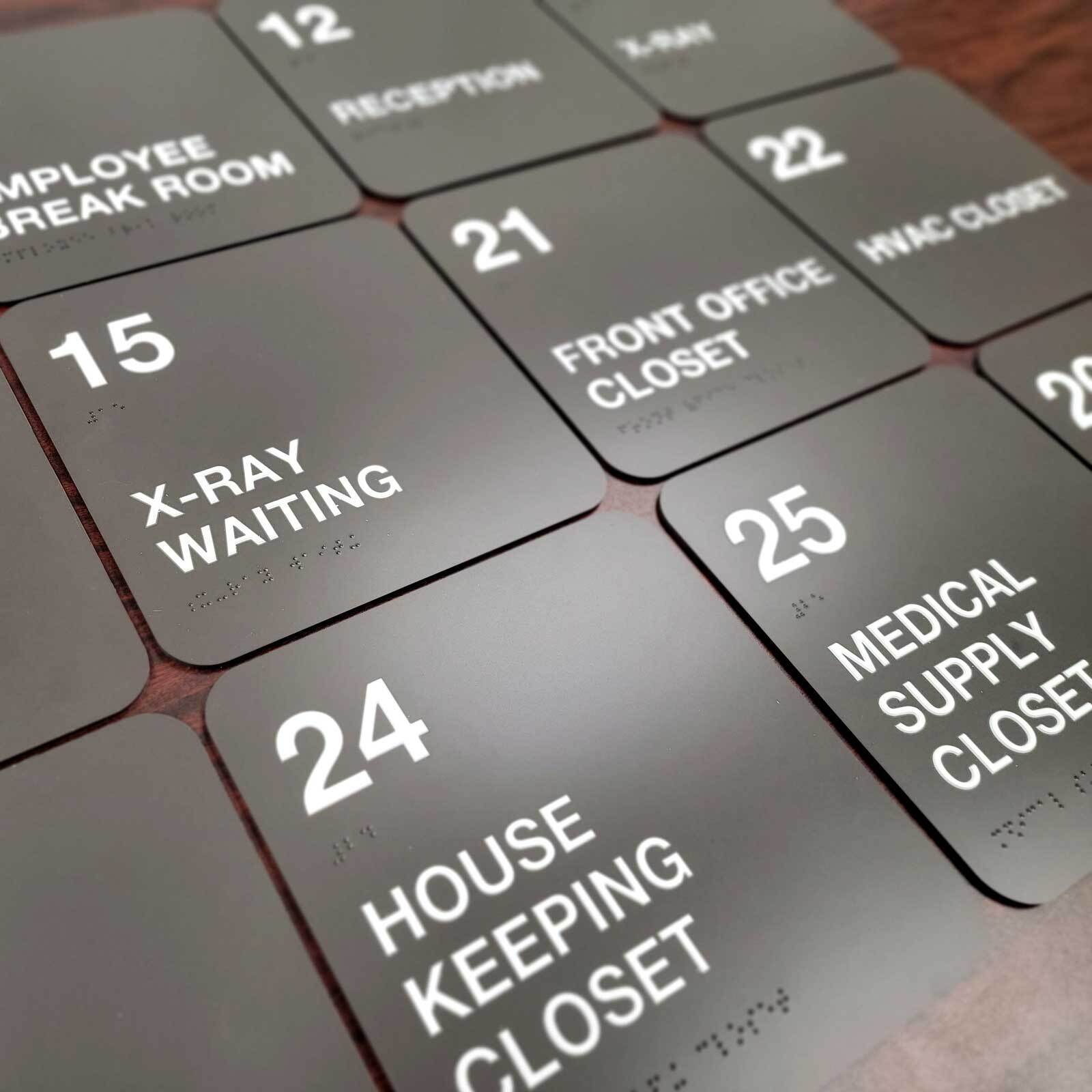 Custom ADA-compliant signs including restroom, wayfinding, and room identification signs for a medical office