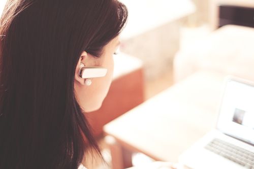 Woman with computer and headset