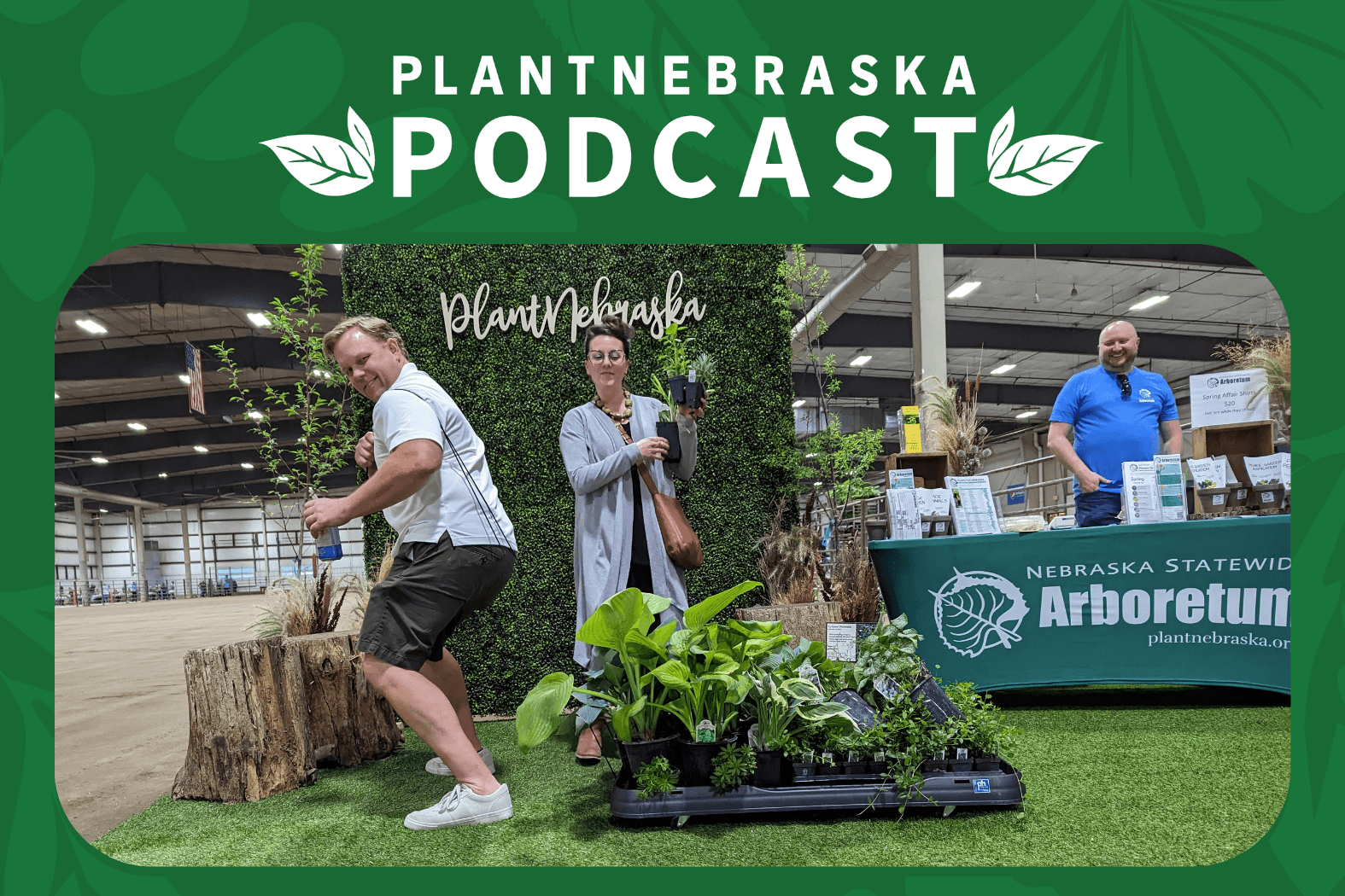 a man being silly while pulling a pallet of plants. the pallet has wheels and is pulled by a rope.