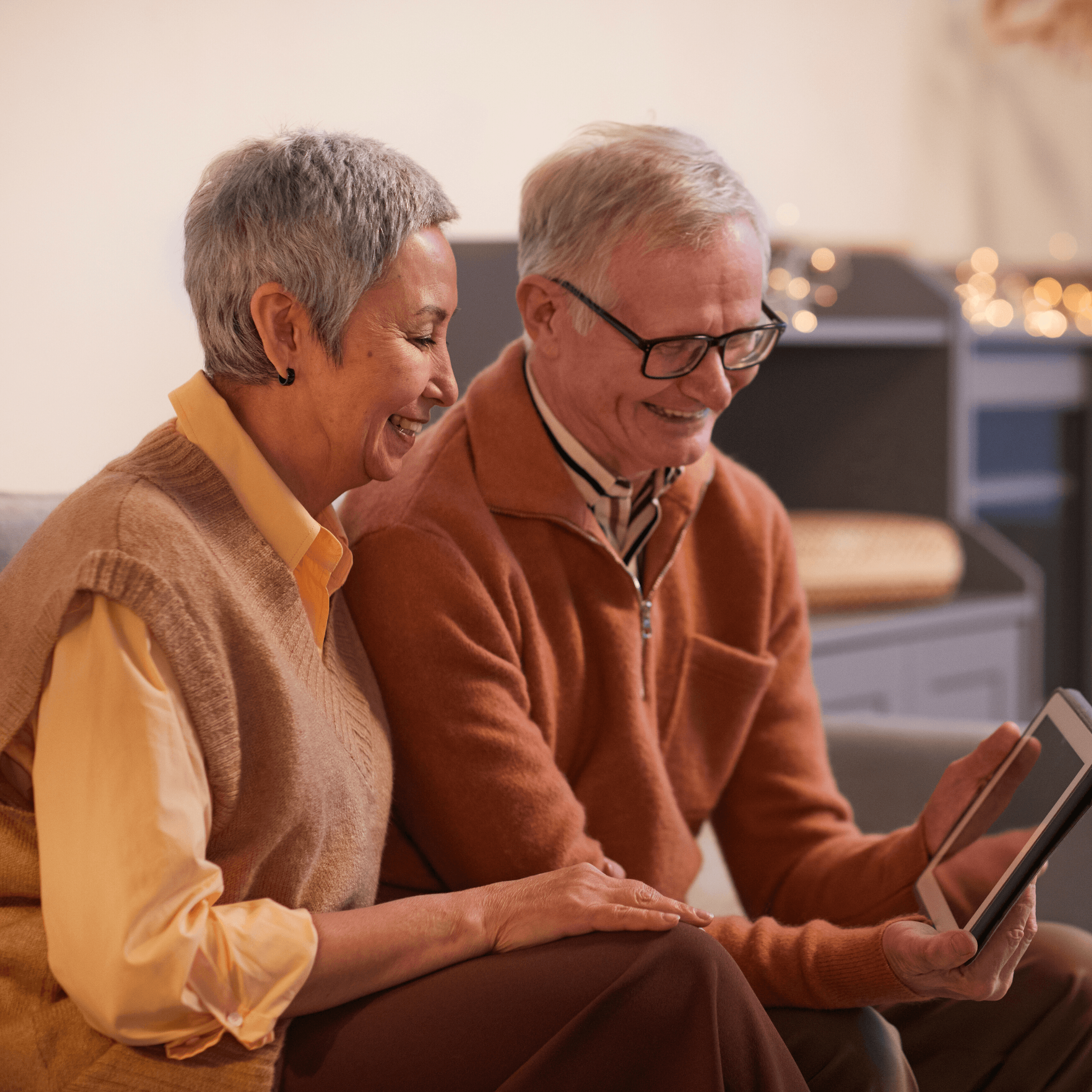 Man and woman sitting and looking at tablet screen together